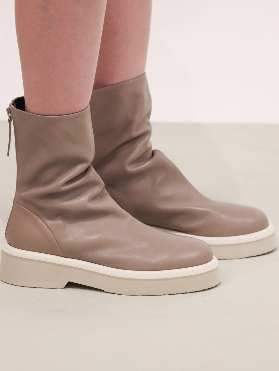 Taupe leather boots with shirring around the top of the ankle, and a short platform tonal sole.