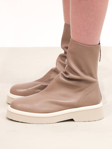Taupe leather boots with shirring around the top of the ankle, and a short platform tonal sole.